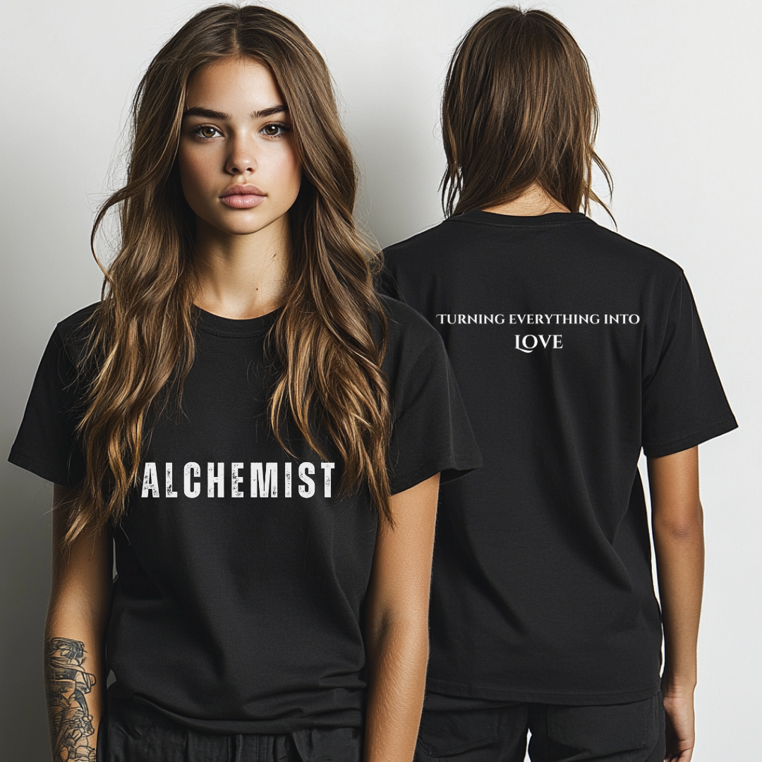 Model wearing crew neck T-shirt that reads ‘ALCHEMIST’ in distressed block letters across the chest. ‘Turning Everything Into Love' in two lines of smaller block letters are written on the back. Embody love in all things.
