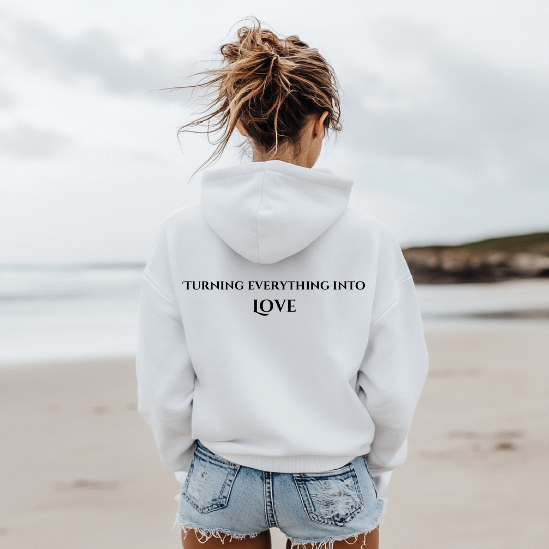 Model wearing hoodie that reads ALCHEMIST in distressed block letters across the chest. "Turning Everything Into Love" in two lines of smaller block letters is written on the back.
Embody love in all things.