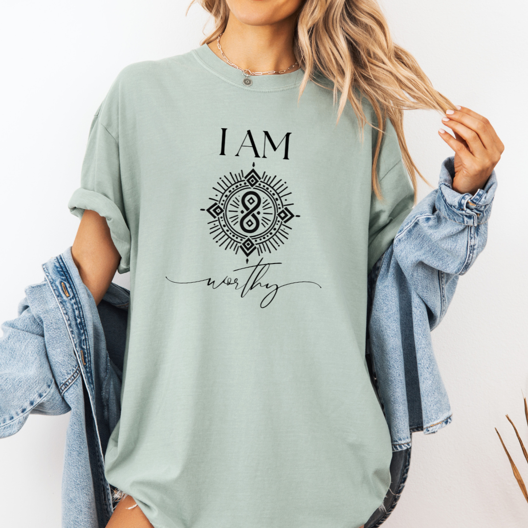Model wearing a crew neck T-shit with symbolic sigil centered on the chest, representing worthy.
The shirt reads 'I AM' in block font above the sigil and 'worthy' in script font below the sigil.
Declare to the world: I AM worthy.
