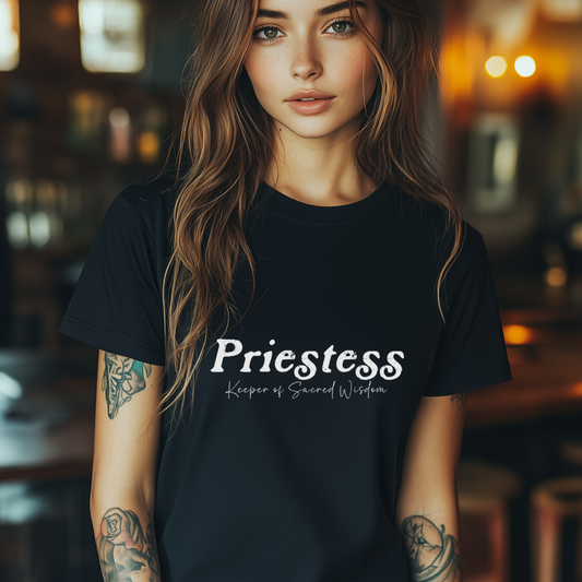 Model wearing a crew neck T-shirt. 
The shirt says “Priestess” in distressed lettering across the chest with “Keeper of Sacred Wisdom” printed in smaller scripted lettering underneath.
Wear, Embody, Be the Priestess.
