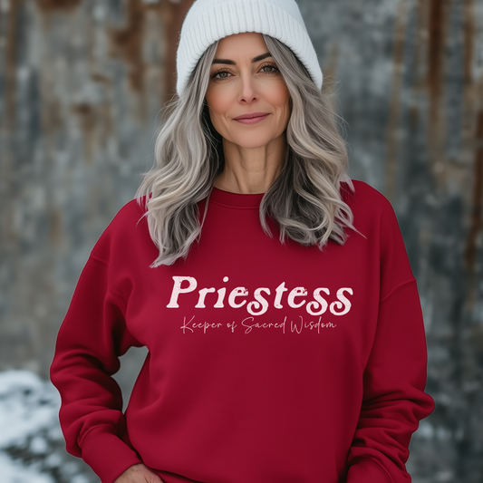 Model wearing a crew neck sweatshirt.
The sweatshirt says “Priestess” in distressed lettering across the chest with “Keeper of Sacred Wisdom” printed in smaller scripted lettering underneath.
Wear, Embody, Be the Priestess.
