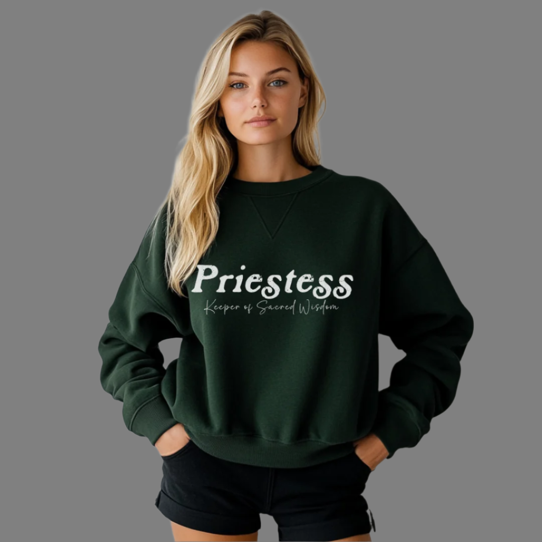 Model wearing a crew neck sweatshirt.
The sweatshirt says “Priestess” in distressed lettering across the chest with “Keeper of Sacred Wisdom” printed in smaller scripted lettering underneath.
Wear, Embody, Be the Priestess.