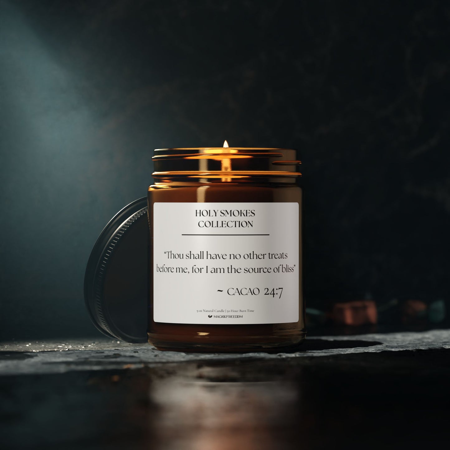 Amber glass jar candle labeled with the Holy Smokes Cacao verse, featuring sacred typography on a minimalist background