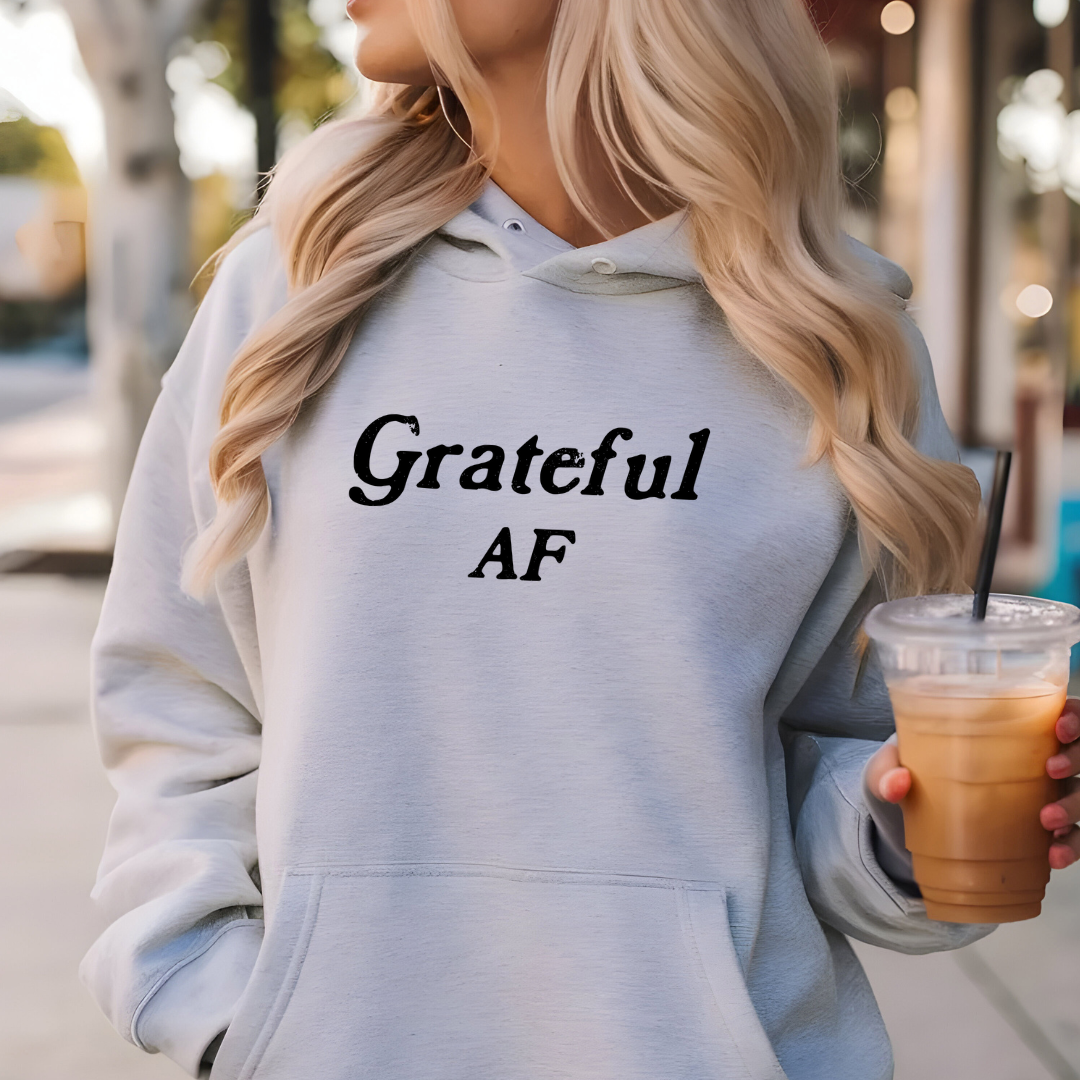 Model wearing a hoodie with Grateful AF printed in block letters and centered on the chest.
Wear it, own it, live it.