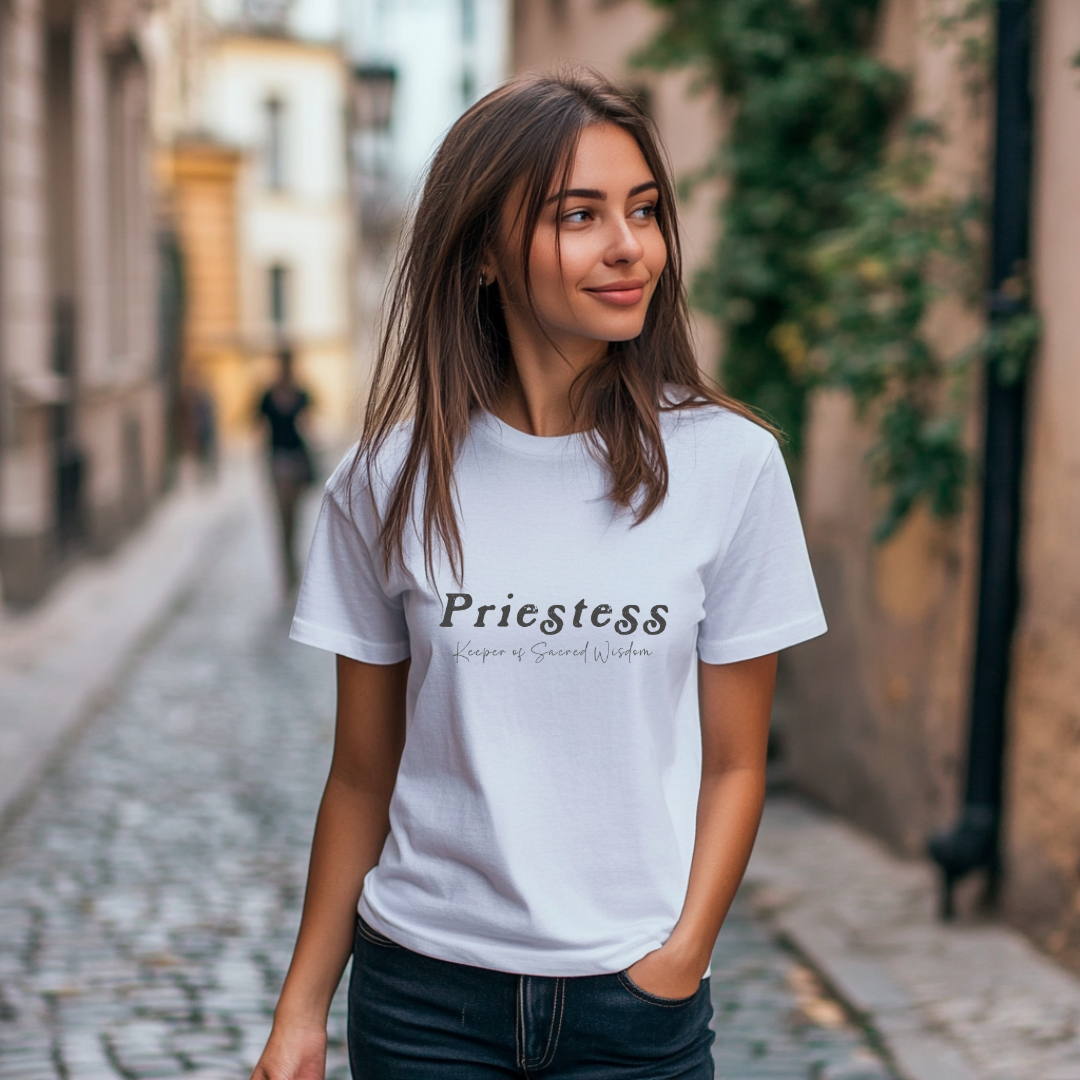 Model wearing a crew neck T-shirt. 
The shirt says “Priestess” in distressed lettering across the chest with “Keeper of Sacred Wisdom” printed in smaller scripted lettering underneath.
Wear, Embody, Be the Priestess